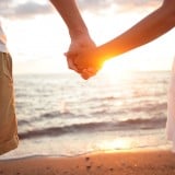 カップル 夫婦 愛情 手をつなぐ 海辺 夕日 恋愛