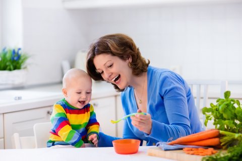 笑顔で離乳食を食べさせるママ